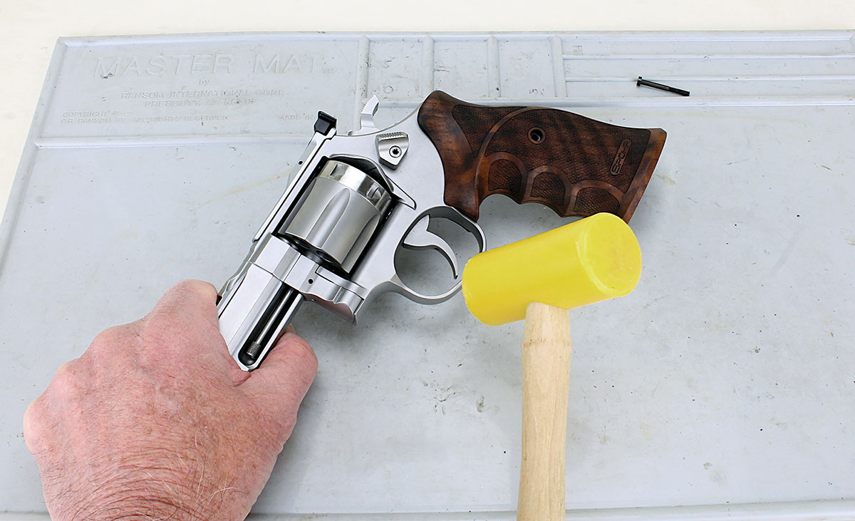 The wooden grips fit tightly to the frame. Rather than damaging the wood by prying, loosen the grips by tapping the trigger guard with a plastic mallet.